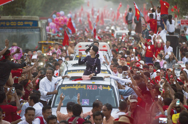 This file photo taken on November 1, 2015 shows Myanmar opposition leader Aung San Suu Kyi gesturing towards supporters as she travels in a motorcade ahead of a campaign rally for the National League for Democracy in Yangon as Myanmar heads to the polls on November 8 (AFP photo)