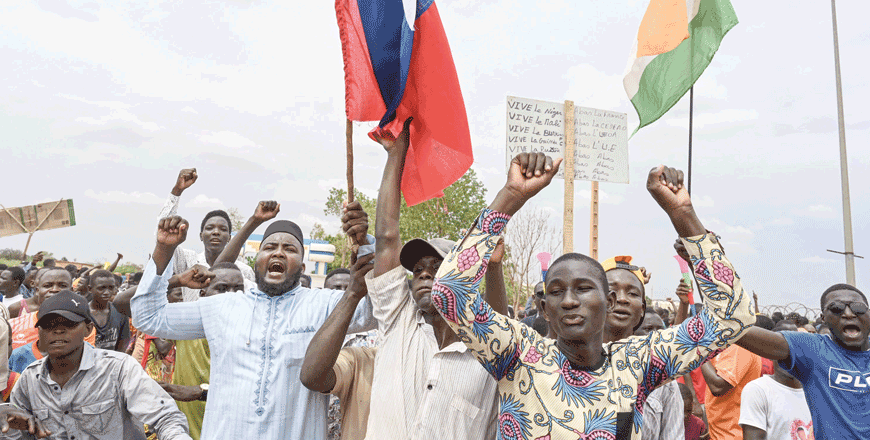 Supporters of Niger's National Council for the Safeguard of the Homeland hold a Niger flag (right) and a Russian flag (left) as they gather for a demonstration in Niamey on Friday near a French airbase in Niger (AFP photo)