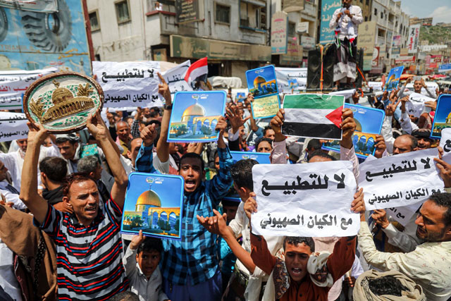A man holds a plaque depicting Jerusalem's Dome of the Rock while others hold signs depicting the landmark and flags of Palestine and Yemen, alongside other signs reading in Arabic 'no to normalisation with the Zionist entity', during a protest in Yemen's third city of Taez on August 21, against the US-brokered deal between the United Arab Emirates and Israel to build ties (AFP photo)