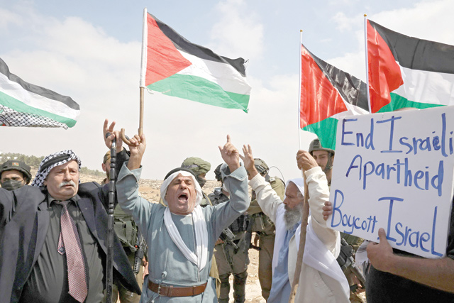 Elderly Palestinian demonstrators chant slogans in front of Israeli soldiers during a demonstration against Israeli land confiscation and the cutting of water supply for Palestinian villages, in the southern area of the West bank town of Hebron, on Saturday (AFP photo)