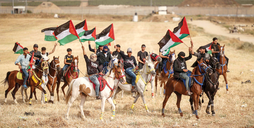 Palestinians waving their national flags take part on horseback in a rally on the 74th anniversary of the Nakbeh at the bodrder east of Gaza City on Saturday (AFP photo)