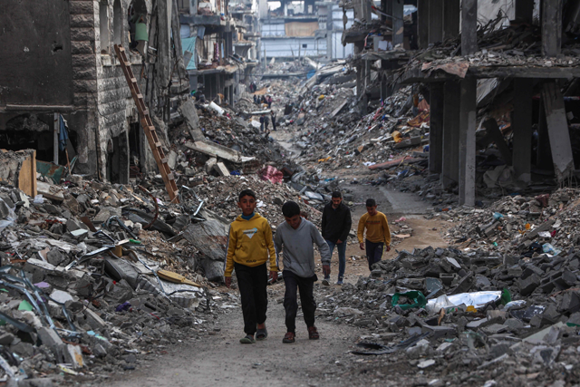 Palestinians walk in a devastated neighbourhood in Beit Lahia in the northern Gaza Strip, ahead of the iftar fast-breaking meal during the Muslim holy month of Ramadan on March 9, 2025 (AFP photo)