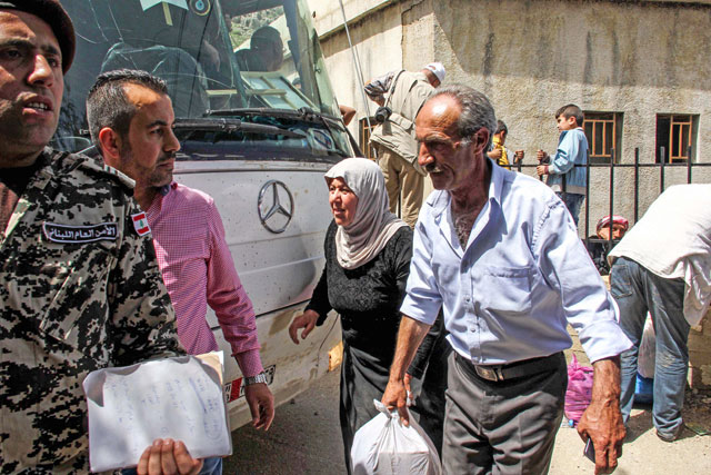 Syrian refugees prepare to be evacuated from the southern Lebanese village of Shebaa, on Wednesday, to return home to their village of Beit Jinn in the southwestern Damascus countryside (AFP photo)