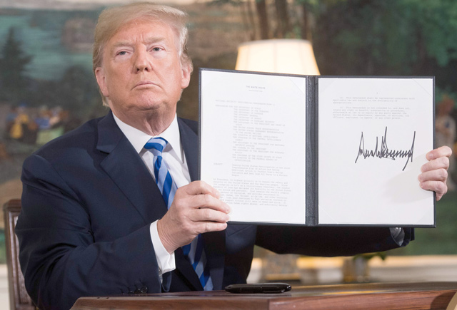 US President Donald Trump signs a document reinstating sanctions against Iran after announcing the US withdrawal from the Iran nuclear deal, in the Diplomatic Reception Room at the White House in Washington, DC, on Tuesday (AFP photo)