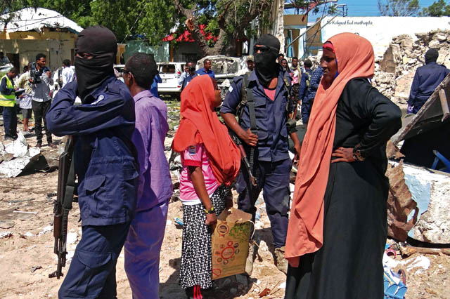 Security forces and civilians stand on the scene of a car bomb attack in Mogadishu in the southern district of Wadajir on Tuesday (AFP photo)