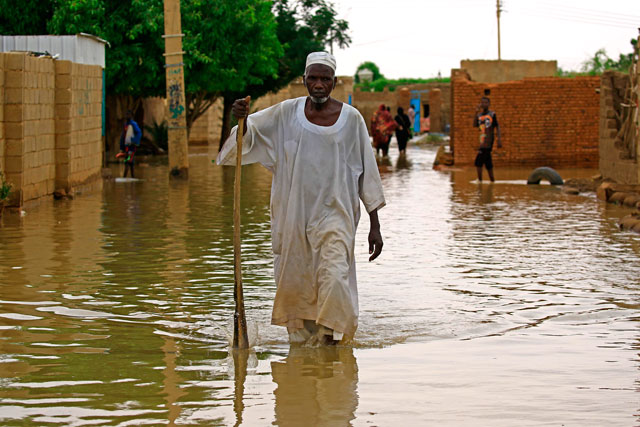 A Sudanese resident wades through floodwater in the capital Khartoum's southern neighbourhood of Al Kalakla on Monday (AFP photo)