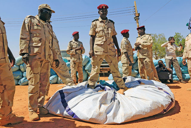 Military men stand on top of cannabis drugs after it was seized by Rapid Support Forces at its headquarters outside Khartoum, Sudan, on Sunday (Reuters photo)