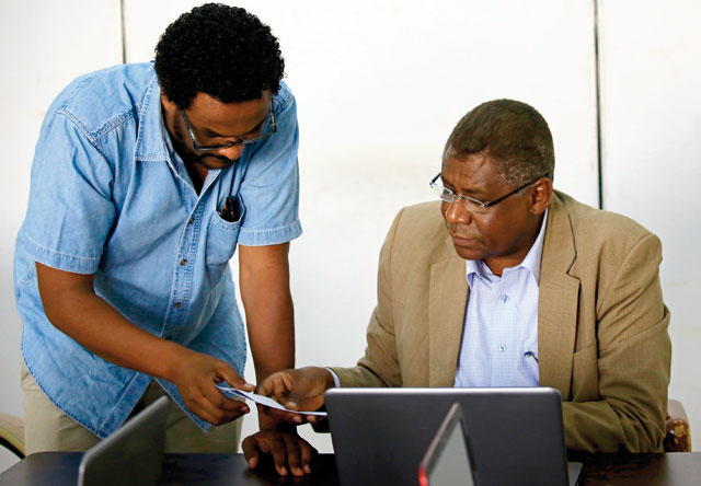 Adil Al Baz (right), editor of online newspaper Al Ahdath News, speaks with a colleague during a meeting with fellow journalists at his office in downtown Khartoum, on Monday (AFP photo)