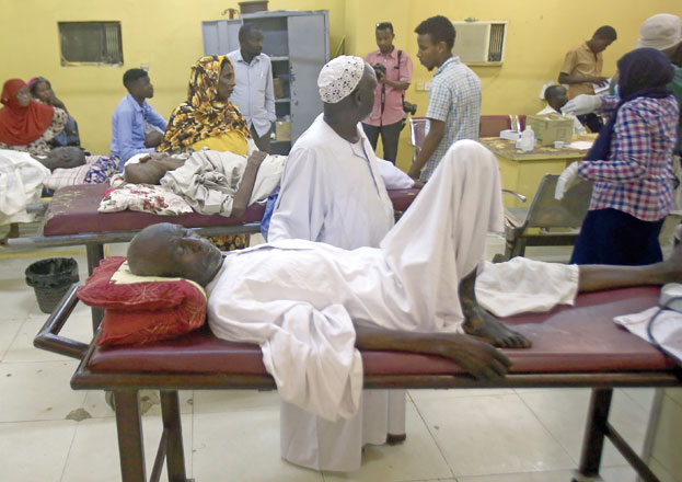 Sudanese people wait for treatment at a hospital in Khartoum's twin city of Omdurman, as doctors take part in the second day of a nationwide civil disobedience campaign called to pressure the ruling military into handing over power, on Monday (AFP photo)