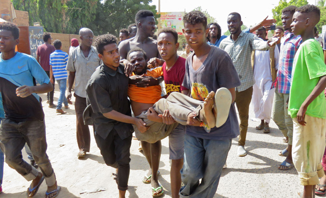 Sudanese carry a man injured during clashes as part of protests against a military coup that overthrew the transition to civilian rule, on October 25, in the capital Khartoum (AFP photo)