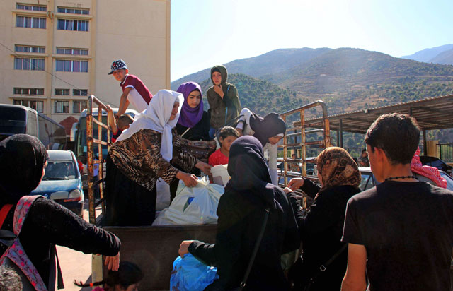 Syrian refugees gather their belongings as they prepare to be evacuated from the southern Lebanese village of Shebaa on Monday (AFP photo)