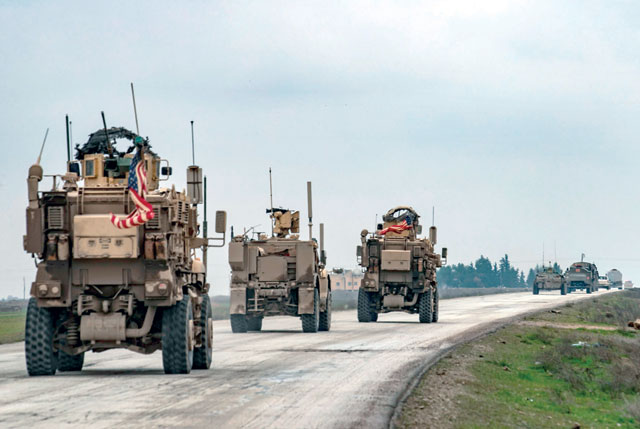 In this file photo taken on January 20, a US military convoy drives behind a similar Russian patrol along the key M4 highway in Syria's northeastern Hasakeh province (AFP photo)