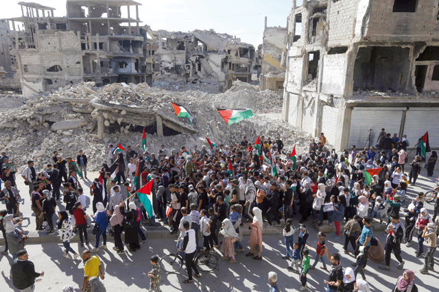 People march during a protest supporting the Palestinian people following Friday Noon prayers in the Yarmuk camp for Palestinian refugees south fo Damascus on Friday (AFP photo)