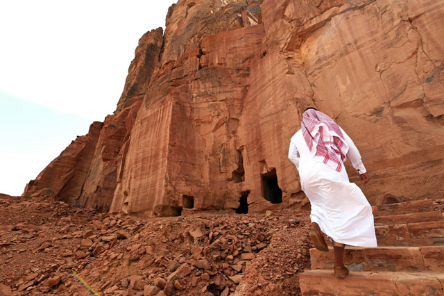 A photo taken on March 31 shows a Saudi man walking near ancient tombs at the Khuraiba archaeological site near Saudi Arabia’s northwestern town of Al Ula (AFP photo)