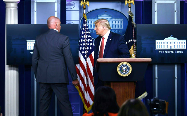 US President Donald Trump is being whisked away by a member of the secret service from the Brady Briefing Room of the White House in Washington, DC, on Monday (AFP photo)