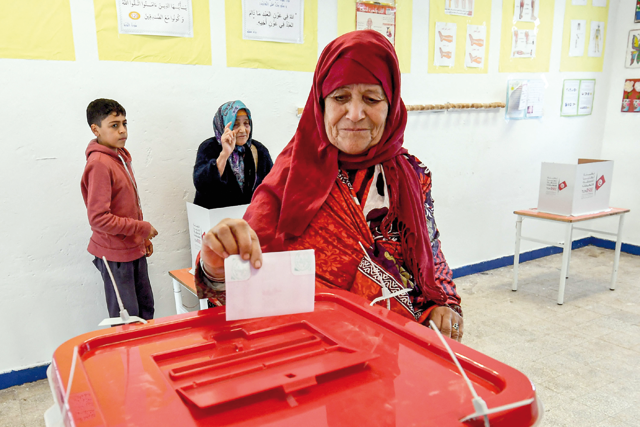 A voter casts her ballot while voting at a polling station during the 2023 local elections in the locality of Mnihla in Ariana province on the outskirts of Tunis on Sunday (AFP photo)