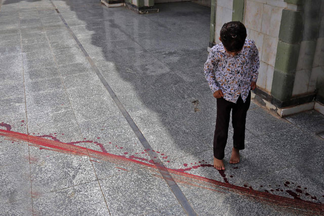 A Yemeni boy steps on a trace of stained-blood on the floor outside a mosque following the assassination of Sheikh Mohammed Al Zabhani, imam and preacher of the largest mosques in the city ‘Masjid Al Saeed’, in the country's third-city of Taez on Monday (AFP photo)