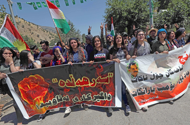 Iraqi Kurds wave Kurdish flags during a demonstration to protest a military operation by the Turkish army against the Kurdistan Workers’ Party in the Qandil Mountain, the PKK headquarters in northern Iraq, on Friday (AFP photo)