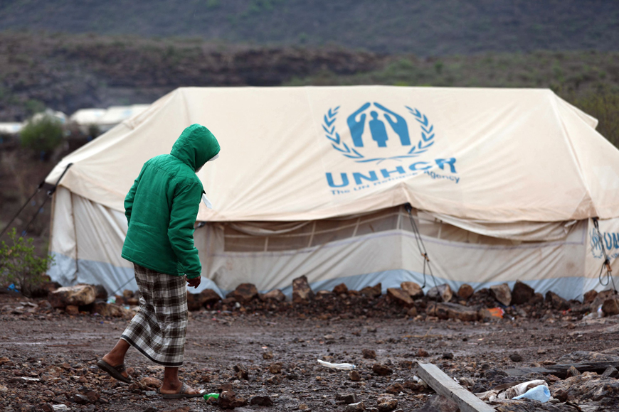 A man walks through the mud past tents at a temporary camp for people displaced by the conflict, which has been inundated after heavy rains, in Yemen's south-western province of Taiz, on Saturday (AFP photo)