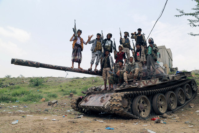 Pro-government fighters stand on the barrel of a tank in an area where they fought against Houthi fighters in the southwestern city of Taez, Yemen, on Sunday (Reuters photo)