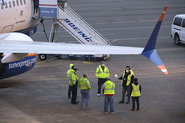 Workers meet on the flight line near Boeing 737 MAX factory on April 21, 2020, shortly after company resumed operations, in Renton, Washington (AFP photo)