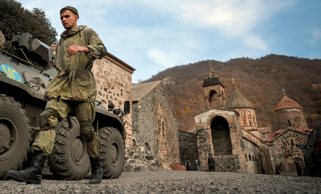 A Russian peacekeeper walks past his armoured personnel carrier stationed in front of the 12th-13th century Orthodox Dadivank Monastery, outside the town of Kalbajar, on Sunday (AFP photo)  