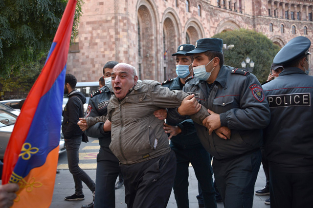 Armenian police officers detain a protestor near the government building after a protest against the country's agreement to end fighting with Azerbaijan over the disputed Nagorno-Karabakh region outside the government headquarters in Yerevan on Tuesday (AFP photo)