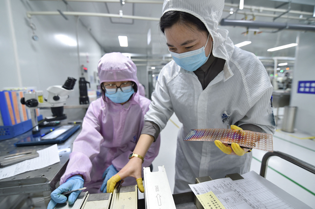 This photo taken on Tuesday shows workers producing semiconductor chips at a workshop in Suqian, in China's eastern Jiangsu province (AFP photo)