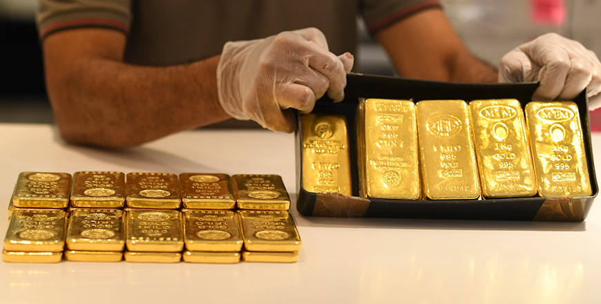 A jeweler showcases bars of the shining metal at a shop at the Dubai Gold Souk in the Gulf emirate on May 13, 2020  (AFP file photo)