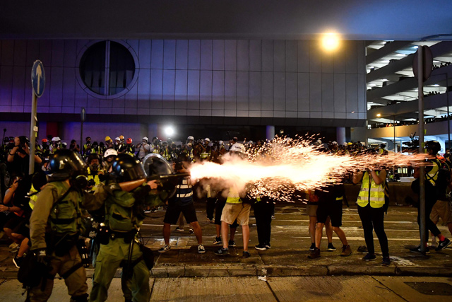 A policeman fires tear gas at protesters to disperse them after a march against a controversial extradition bill in Hong Kong on Sunday (AFP photo)