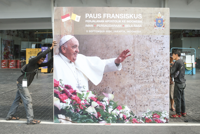 Workers install a billboard for the upcoming mass that will be led by Pope Francis at the Gelora Bung Karno Stadium in Jakarta on Tuesday (AFP photo)