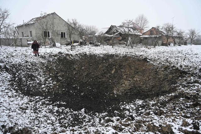 Yaroslava Sukach, 77, a local resident whose house was destroyed stands next to a crater following a missile strike on the village of Sknyliv, some 60km from Lviv, on January 15, 2025 (AFP photo)
