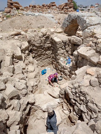 An Umayyad floor (bottom: during conservation) with Early and Middle Islamic-period walls on the southern side of the Roman arch, with the qasr visible in the background (Photo by Mariusz Burdajewicz)