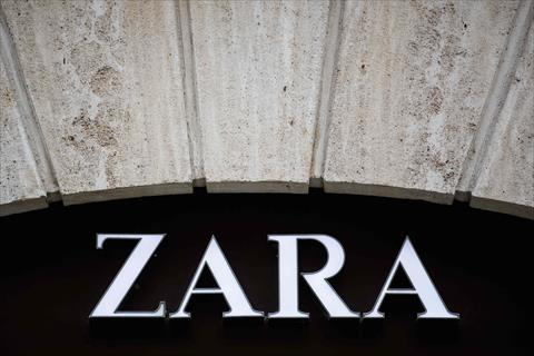 People pass by a Zara shop announcing discounts on the first day of the winter sales in Barcelona on January 7, 2017 (AFP photo)