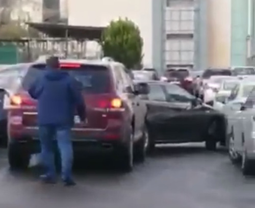 In this screengrab from a viral video, a woman slams into the back of a car after a verbal altercation on Black Friday  (Photo courtesy of Facebook)