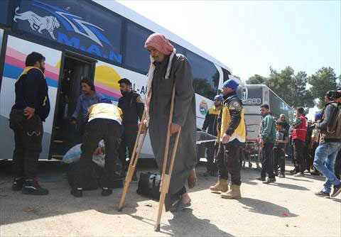 A man walks with crutches after the fifth convoy, carrying those evacuated from Eastern Ghouta besieged by the Assad regime and its supporters, arrives in Hama province, Syria, on Tuesday (Anadolu Agency photo)