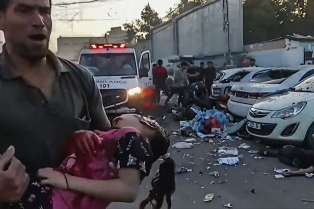 In this image grab taken from an AFPTV video footage shows a man carries an injured girl a he runs in near an ambulance damaged in an Israeli strike in front of Al Shifa hospital in Gaza City on Friday (AFP photo)