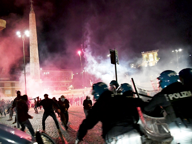 Italian police officers clash with far right Forza Nuova party activists during a protest against the government restriction measures to curb the spread of COVID-19, at central Piazza del Popolo, in Rome, Italy on Saturday (AFP photo)