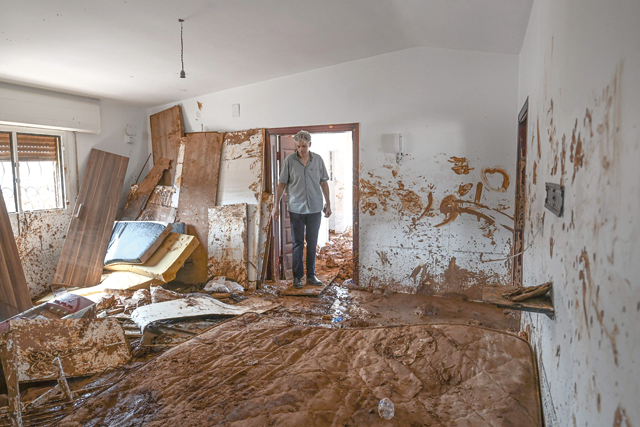 A man inspects a mud covered room in a house in the eastern city of Soussa on Friday, following deadly flash floods (AFP photo)