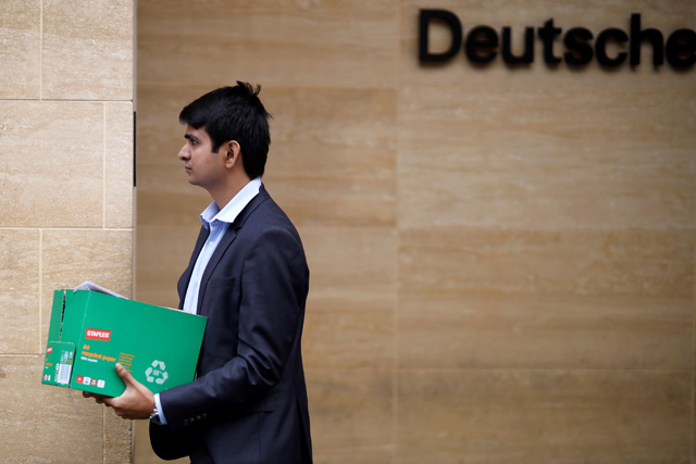 A man carries a box as leaves from the offices of German bank Deutsche Bank in central London on Monday  (AFP photo)