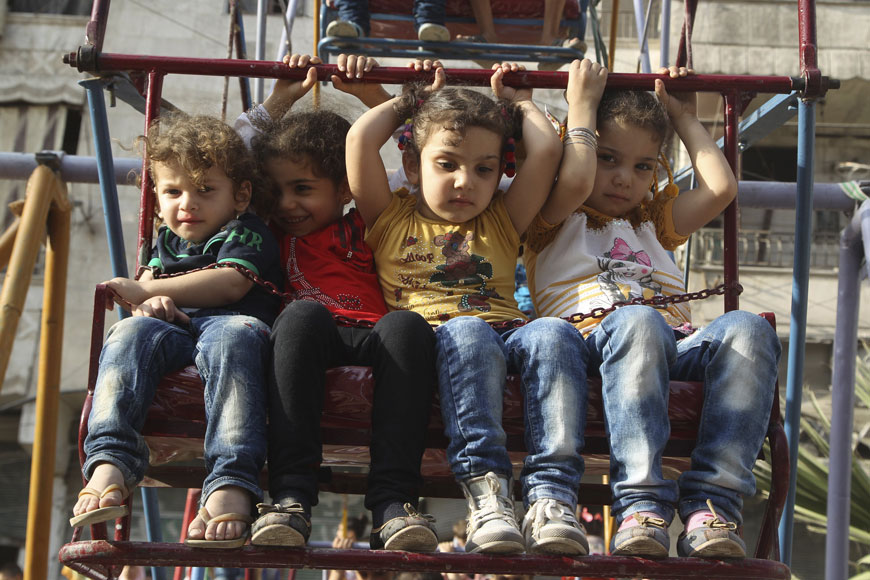 Children sit on a ferris wheel during Eid celebrations in Al Fardous neighbourhood of Aleppo, Syria, on Sunday (Reuters photo)