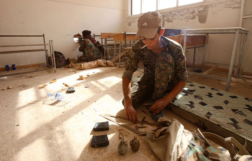 Members of the Kurdish People’s Protection Units take position in a classroom in the village of Maarouf in the northeastern Syrian province of Hasakeh on July 16, as they battle Daesh militants (AFP photo)