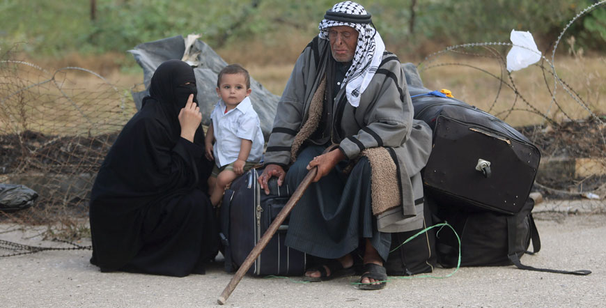 Palestinians wait for travel permits to cross into Egypt at the Rafah border crossing between Egypt and southern Gaza Strip on Monday (Reuters photo)