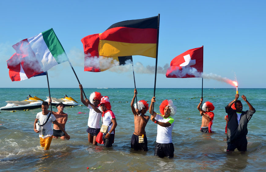 Tourists take part in a gathering in solidarity with Tunisia’s tourism industry, on Monday, on the island of Djerba, following a deadly gun attack at a holiday resort near Sousse (AFP photo)