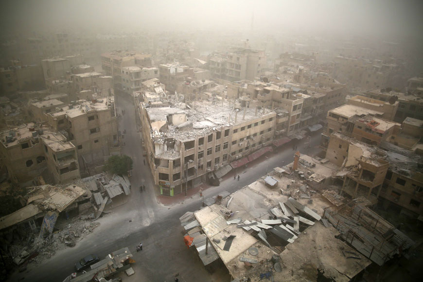 A photo taken on Monday shows a general view of damaged buildings in the rebel-held area of Douma, east of the capital Damascus, as a sandstorm blows over the city (AFP photo)