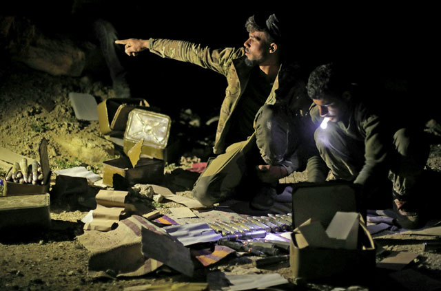 A fighter of Syrian Democratic Forces gestures as he sits near ammunition in the village of Baghouz, Deir Ezzor province, Syria, on Monday (Reuters photo)