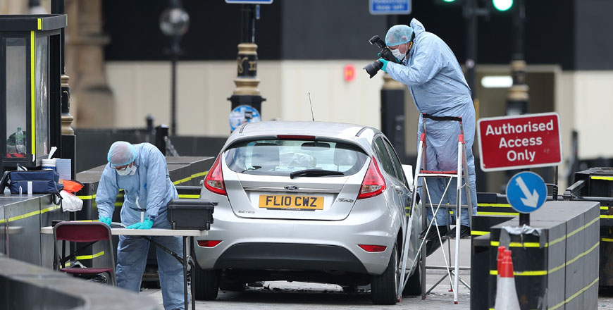 Forensic police officers work around a silver Ford Fiesta car that was driven into a barrier at the Houses of Parliament in central London on Tuesday (AFP photo)