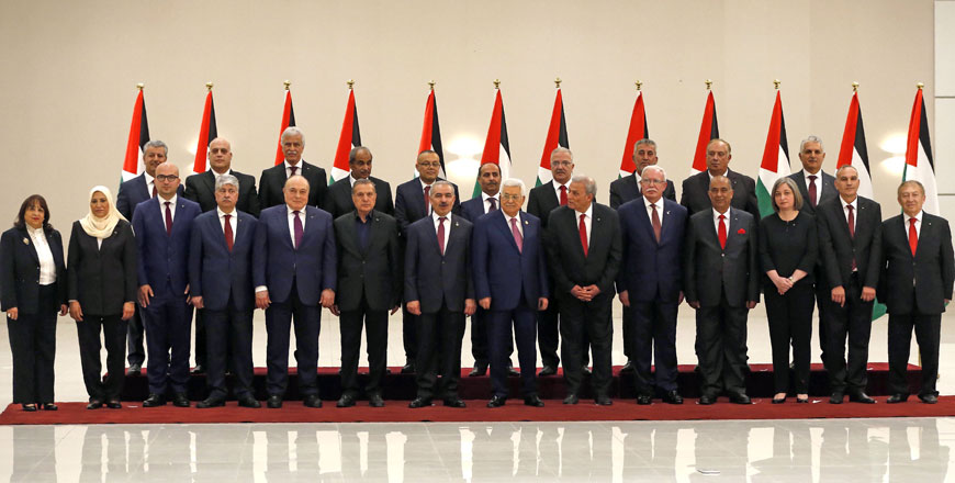   Palestinian President Mahmoud Abbas (7th- right) poses for a group photo with the members of the new Palestinian government in the Israeli-occupied West Bank town of Ramallah on Saturday (AFP photo)