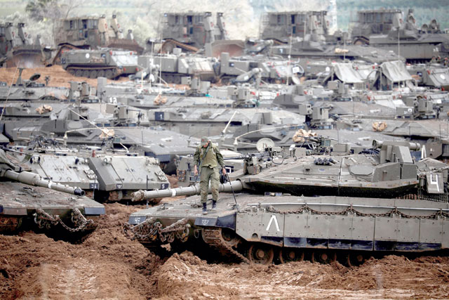 An Israeli soldier stands atop a tank near the border with Gaza, in southern Israel, on Wednesday (Reuters photo)