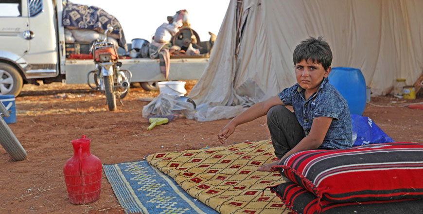A Syrian child sits on a mattress next to cushions outside a tent at a camp for displaced civilians fleeing from advancing government forces, close to a Turkish military observation point near the village of Sarman in the rebel-held northwestern Idlib province on September 1 (AFP photo)